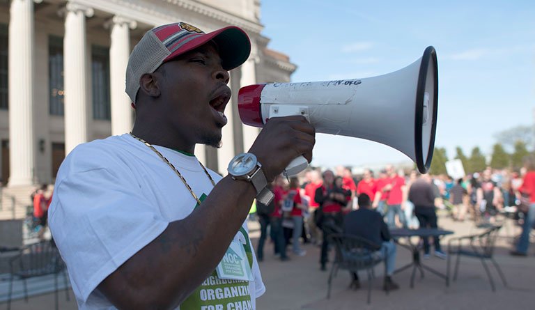African American Male On A Bullhorn In Front Of A Congress Building