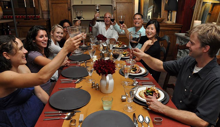 Group Of People Making A Toast At The Dinner Table