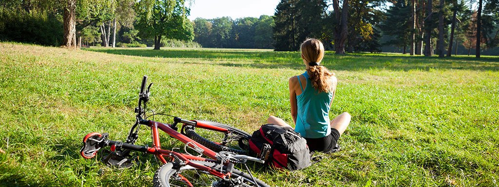 Woman Sitting With Her Bike In The Park