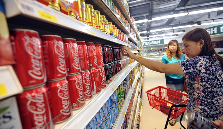 Woman Picking Up Soda Inside Of A Supermarket