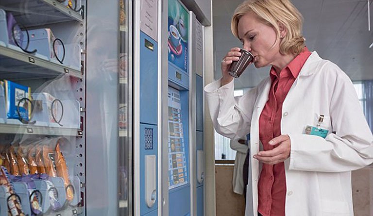 Hospital Personnel Drinking Soda From Vending Machine