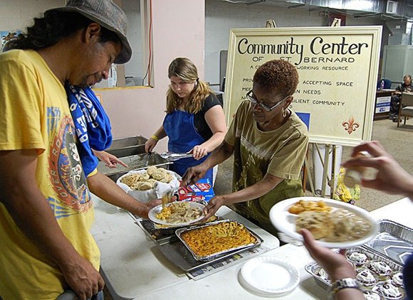 Woman Handing Out Food At A Community Center