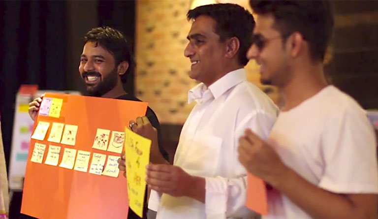 Men Holding Up Posters At A Presentation