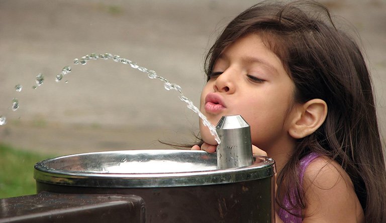Girl At Outdoor Water Fountain