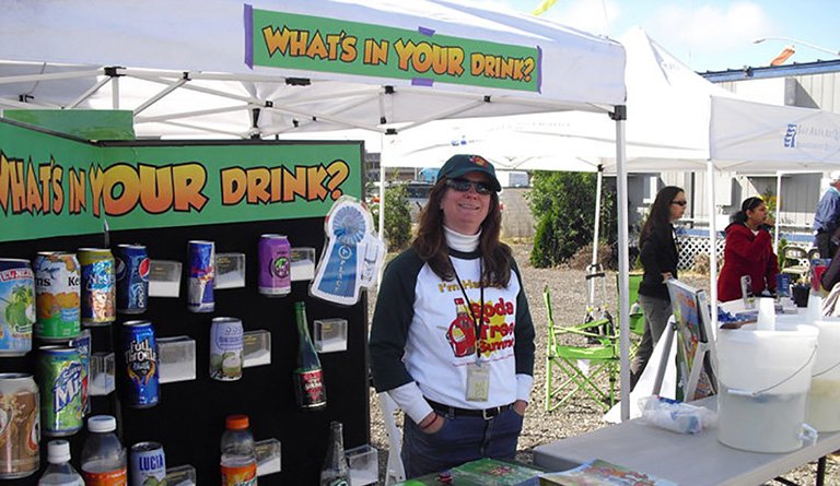 Women Standing At A Sugar Awareness Table